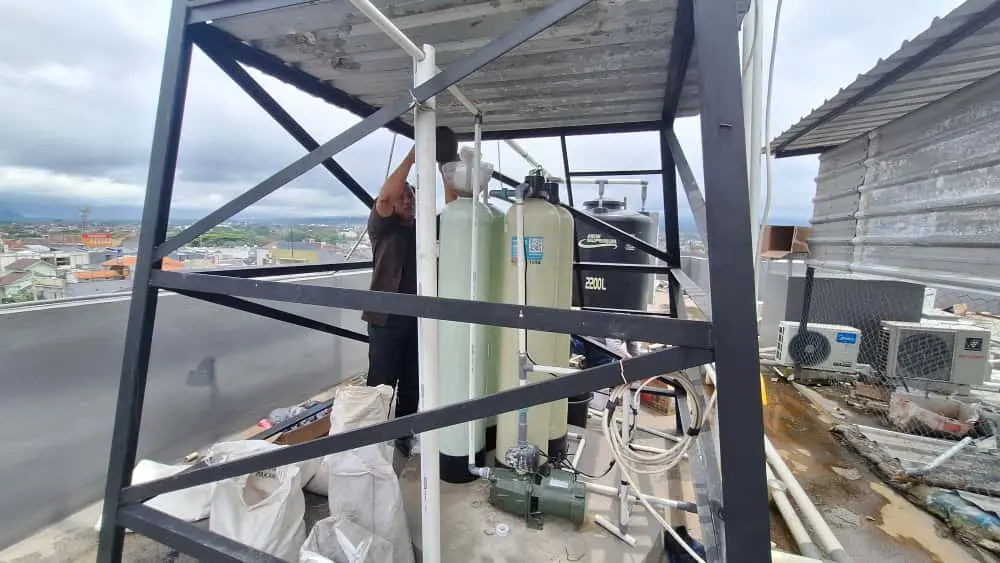 Tim EcoFilter sedang melakukan instalasi jenis filter air untuk air keruh berbau di sebuah rumah di Kota Malang